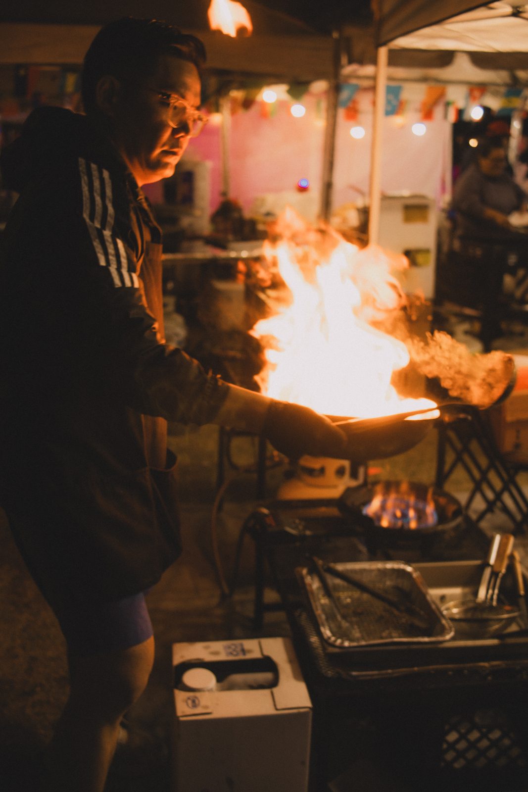 Chef cooking with flames in a wok